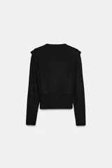Jersey de punto de cuello redondo y manga larga, con diseño estructurado que incorpora hombreras marcadas y detalles de pliegues en los hombros.