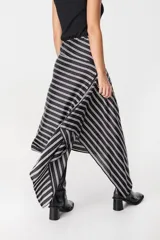 Falda midi de corte asimétrico con diseño de rayas horizontales en blanco y negro. Confeccionada en tejido satinado con caída fluida.