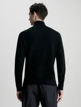 Sweater negro de lana merino con cuello alto y cremallera corta.