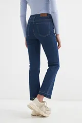 Pantalón de jean azul oscuro, de corte cropped y acampanado, con ruedo desflecado.