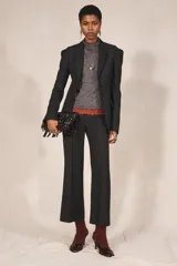 Blazer negro de corte recto de la colección Zara Studio, con solapas de muesca, cierre frontal de dos botones y bolsillos con solapa. Presenta mangas largas con pliegues estructurados en los hombros y forro interior a rayas a contraste.