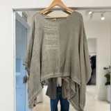 Blusa verde militar de lino, con diseño holgado, mangas amplias y detalles de parches rectangulares con bordes deshilachados en el frente.