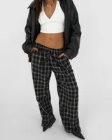 Pantalón de corte holgado y tiro medio, con estampado de cuadros en tonos negro y gris. Presenta cintura elástica con cordón ajustable y bolsillos laterales.