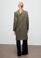 Abrigo largo de corte recto en color verde militar, confeccionado en tejido mezcla de lana. Cuenta con cuello de solapa con muesca, cierre cruzado de doble botonadura, mangas largas y dos bolsillos con solapa en la parte frontal.