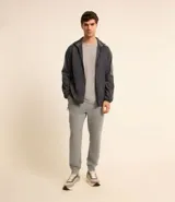 Pantalón deportivo de hombre color gris, liso, con ajuste elástico en la cintura y bolsillos laterales.