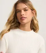 Blusa de punto color blanco con cuello alto y manga larga.