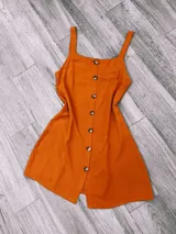 Vestido corto color mostaza con breteles finos y botones frontales. Corte acampanado.