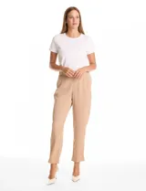 Pantalon de corte relajado color beige, con cintura plana en el frente y elástica en la parte posterior. Presenta pierna de corte recto, bolsillos laterales diagonales y bolsillos traseros simulados.