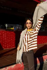 Remera de manga larga con diseño de rayas horizontales y verticales en blanco y negro, con estampado frontal multicolor.