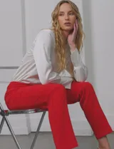 Pantalón sastrero de corte slim, color rojo, con diseño de tiro medio, bolsillos laterales y nervadura vertical marcada en el frente.
