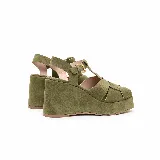 Sandalias de plataforma con taco corrido y tiras cruzadas en el empeine, confeccionadas en gamuza color verde militar. Cuentan con tira en T y pulsera ajustable al tobillo con hebilla metálica dorada.