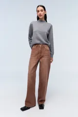 Jean marrón de tiro alto, con pierna levemente acampanada y cierre con botones metálicos.