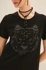 Remera de algodón color negro, con cuello redondo y mangas cortas. Presenta un estampado frontal de un tigre en tonos oscuros y texturas sutiles.