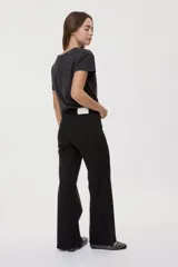 Pantalón de tiro medio y corte wide leg color beige, con diseño clásico de cinco bolsillos, presillas para cinto y cierre frontal con botón y cremallera.