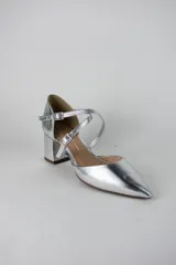 Sandalia de tacón cuadrado color blanco, con diseño de punta fina cerrada y tiras cruzadas ajustables con hebillas metálicas doradas.