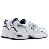 Championes New Balance modelo 530 de estilo retro para running, confeccionados en malla blanca con superposiciones plateadas y azul marino. Cuentan con amortiguación ABZORB en la suela y el característico logotipo "N" en los laterales.