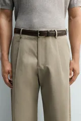Cinturón de cuero negro con doble pespunte y hebilla metálica rectangular.