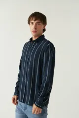 Camisa de mangas largas con estampado a rayas verticales en tonos verde oliva, blanco y azul. Corte regular y logo bordado en el pecho. Confeccionada en viscosa.