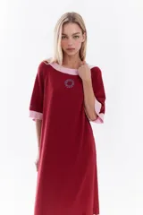 Vestido midi de punto color rojo con detalles en rosado contrastante en cuello, mangas y ruedo. Diseño holgado con mangas cortas y bordado sutil en el pecho.