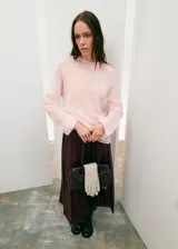 Falda midi plisada de cuero sintético en color bordó, con diseño de talle alto y corte recto.
