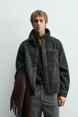 Sobrecamisa de corte relajado confeccionada en tejido con textura efecto pelo. Presenta diseño de cuadros en tonos verde y negro, cuello solapa, cierre frontal con botones, manga larga con puños abotonados y un bolsillo de plastrón en el pecho.