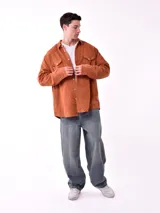 Sobrecamisa de hombre color azul marino, confeccionada en tejido de pana con textura acanalada. Presenta cuello camisero, cierre frontal con botones blancos y dos bolsillos de parche con solapa en el pecho.