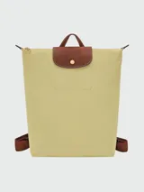 Mochila Longchamp modelo Le Pliage Original en tamaño M, color rosado con solapa y detalles en cuero marrón. Cuenta con correas ajustables de tela y cierre superior con solapa de botón a presión.