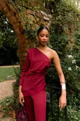 Top asimétrico color burdeos, con una manga larga y el otro hombro descubierto. Presenta drapeado en el lateral y un bajo asimétrico.