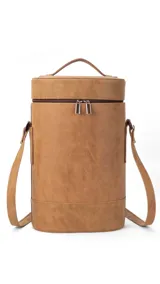 Matera cilíndrica color marrón claro, con cierre superior y correa larga regulable.