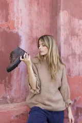 Sweater de tejido de punto grueso color beige, con cuello redondo y mangas largas con puños ajustados.