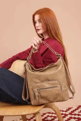 Cartera mochila color tostado, de cuero sintético, con compartimento principal amplio y bolsillos frontales con cierre. Tiene correas ajustables y asa superior para llevar al hombro o como mochila.