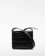 Bandolera pequeña de piel bovina negra con grabado de cocodrilo. Presenta solapa con cierre magnético, asa larga regulable y bolsillo interior con cierre.