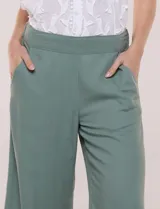 Pantalón crop de lino y rayón, con diseño wide leg de corte holgado, estampado tropical de hojas en tonos verde, azul y marrón sobre fondo blanco. Cuenta con pretina trasera elastizada y bolsillos delanteros.
