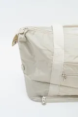 Bolso tipo tote negro con asas de hombro resistentes, cierre superior y un amplio bolsillo frontal con cierre.