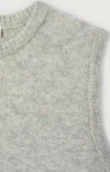 Chaleco de punto sin mangas, color gris, con cuello redondo y corte holgado. Confeccionado con hilo italiano de textura mullida y compacta.