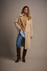 Trench largo color beige de gamuza, con solapas amplias, charreteras en puños y cinturón de la misma tela.