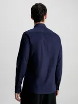 Camisa azul marino de popelín de algodón elástico, corte slim, con cierre frontal de botones y logo bordado en el pecho.