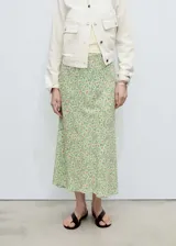 Falda midi de corte evasé con estampado floral sobre fondo verde. Presenta cintura elástica y diseño fluido en tejido de gasa con forro interior.