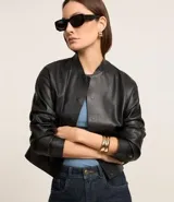 Blusa sin mangas color blanco, confeccionada en tejido de punto acanalado, con cuello redondo.