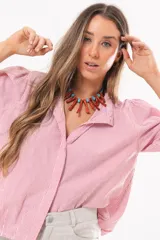 Camisa de manga larga con diseño a rayas rojas y blancas, cuello camisero y cierre frontal con solapa.