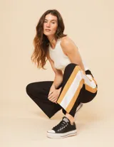 Pantalón palazzo color beige con cintura elastizada y dos franjas verticales en los laterales, una plateada y otra blanca.