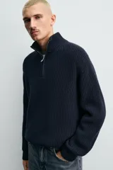 Jersey de punto perlado con cuello perkins y cierre frontal de cremallera. Presenta un corte regular fit, manga larga y acabados en rib en puños y bajo.