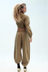 Pantalón fluido confeccionado en mezcla de modal, de tiro medio con cintura elástica ajustable con cordón y bolsillos laterales, en color tostado.