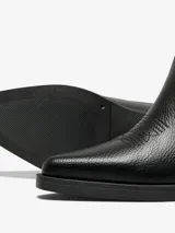 Botas de caña alta color negro con punta afilada, diseño bordado y tacón bajo.