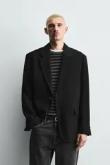 Blazer de corte relajado confeccionada en tejido fluido con mezcla de viscosa. Presenta cuello con solapas de muesca, manga larga con puños abotonados, bolsillos de solapa en la cadera y cierre frontal con botones.