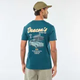 Camiseta de cuello redondo y manga corta en color azul petróleo, con estampado gráfico pequeño en el pecho que incluye el texto 'Deacon's'.