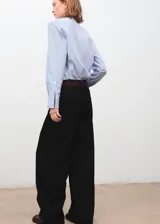 Jeans negros de tiro medio, estilo barrel y diseño balloon, confeccionados en algodón. Cuentan con cinco bolsillos, parches decorativos y cierre de botones.