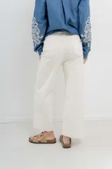 Jean de tiro alto, recto a la pierna, con cinco bolsillos, cierre frontal con cremallera y un botón. Pespunte en rosa.