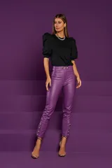 Pantalón skinny de cuero sintético color violeta, con talle alto, cinturón con hebilla metálica y detalle de tachas en el ruedo.