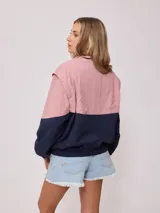 Campera rompevientos Rusty de nylon, color rosa y azul marino, con cierre frontal y puños elastizados.